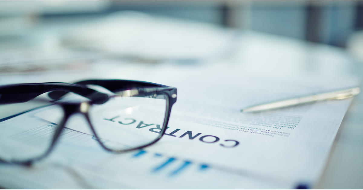 Close up of legal contract with glasses on table-LinkedIn